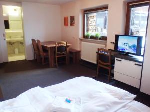 a room with a bed and a table and a television at Haus Arnold by Châtel Reizen in Sölden