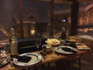 drewniany stół z płytami i kieliszkami do wina w obiekcie L'Eau-Vive w mieście Leukerbad