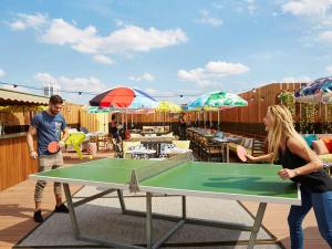 een man en een vrouw die tafeltennis spelen op een tafel bij Mama Shelter Paris East in Parijs