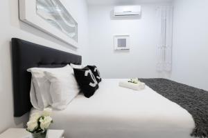 a bedroom with a large white bed with white pillows at Apartamentos Day Madrid SOL Centro Gran Via in Madrid