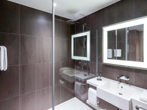 
a bathroom with a sink and a mirror at Novotel Amsterdam Schiphol Airport in Hoofddorp
