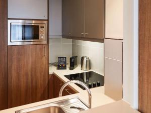 a kitchen with a sink and a microwave at Aparthotel Adagio Birmingham City Centre in Birmingham +37 photos
