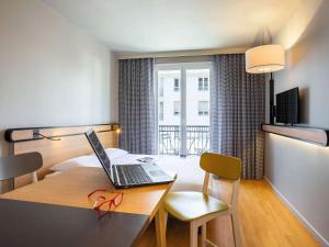 a room with a desk with a laptop on it at Aparthotel Adagio Access La Défense Puteaux in Puteaux