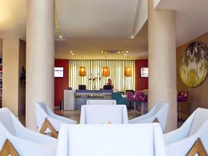 a dining room with white tables and chairs at Mercure Santa Marta Emile in Santa Marta