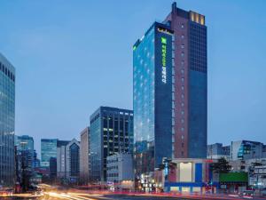 首尔ibis Styles Ambassador Seoul Myeong-dong的夜晚城市中的高楼