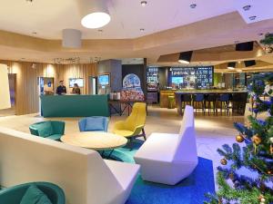 a hotel lobby with a christmas tree in the center at Novotel Krasnoyarsk Center in Krasnoyarsk