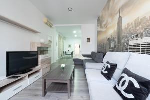 een woonkamer met een witte bank en een tv bij Apartamentos Day Madrid SOL Centro Gran Via in Madrid