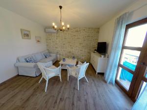 a living room with a couch and a table and chairs at Villa NOAH - 4 bedrooms, 4 bathrooms, heated inside pool, jacuzzi, sauna, gym in Kornić