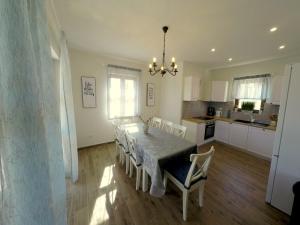 a kitchen and dining room with a table and chairs at Villa NOAH - 4 bedrooms, 4 bathrooms, heated inside pool, jacuzzi, sauna, gym in Kornić
