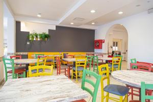 an empty restaurant with tables and colorful chairs at Mare Home Brunch&Beauty - Adults Only in Cesenatico