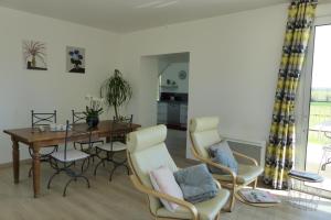 ein Wohnzimmer mit einem Esstisch und Stühlen in der Unterkunft Gîte La Maison d'Edouard in Villers-Carbonnel