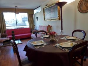 a dining room table with plates and wine glasses at Costanera Center Apartment in Santiago