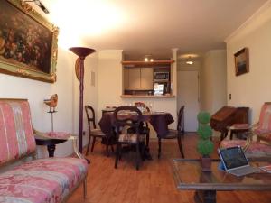 sala de estar con mesa y sillas en Costanera Center Apartment, en Santiago