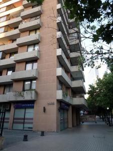 un edificio alto en una calle al lado de un edificio en Costanera Center Apartment, en Santiago