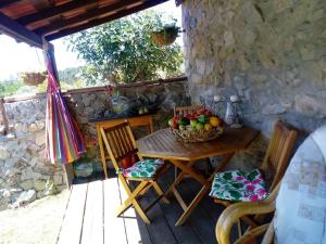ein Holztisch mit einem Obstkorb auf einer Veranda in der Unterkunft Casa do Trapo in Abrantes