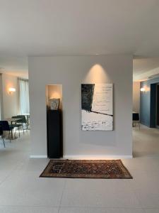 Habitación con una pared blanca con alfombra y una foto en HT Hotel Trieste en Gradisca dʼIsonzo