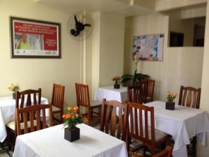 伊塔雅伊的住宿－Hotel Linhares，用餐室配有桌椅和鲜花