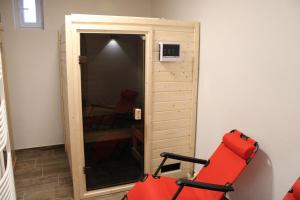 um quarto com um armário com uma cadeira vermelha e um espelho em Mentenwirt Pension&Appartements em Sankt Martin