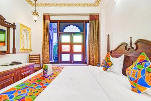 a bedroom with a large bed and a window at FabHotel Shree Villas in Jaipur