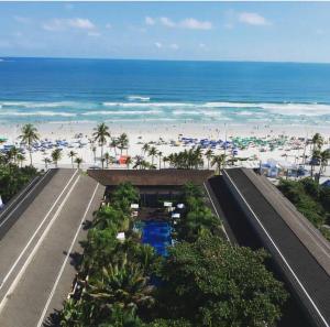 uma vista para a praia a partir da varanda de um resort em Residências Garcez, paraíso à beira da praia Enseada, Guarujá no Guarujá