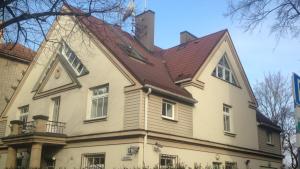 een groot wit huis met een rood dak bij Rock'n'hostel in Vilnius