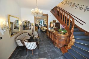 a living room with a staircase and chairs and a table at Hotel Rheinischer Hof in Erkelenz