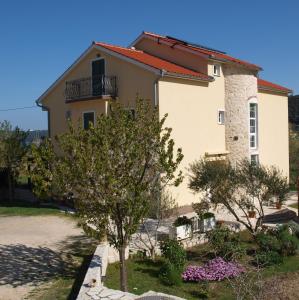 une maison avec un arbre en face dans l'établissement Apartments Batistić, à Supetarska Draga