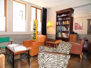 a living room with orange chairs and a book shelf at Detective Hotel in Étretat