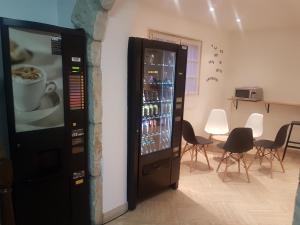 a vending machine with a cup of coffee in a room at Hôtel Le Sainte Florence in Sainte-Florence
