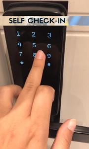 a hand is pressing the button on a microwave at Rainbow Apartments 3 in Krakow
