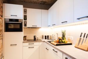 a kitchen with white cabinets and a counter top at Luxurious Urban Living - Premium Downtown Apartments next to HBF in Berlin