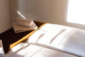 a bed with a towel sitting on top of it at Luxurious Urban Living - Premium Downtown Apartments next to HBF in Berlin