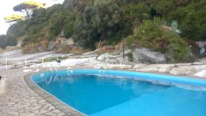 een groot blauw zwembad naast een berg bij VILLA SOLEIL in Massa Lubrense