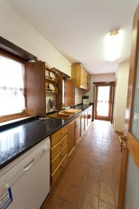 a kitchen with wooden cabinets and a tile floor at A. Montesinho Turismo in Bragança