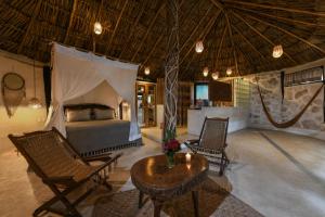 a bedroom with a bed and chairs and a table at Diamante K - Inside Tulum National Park in Tulum +57 photos