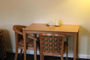 a wooden table with two chairs and a table with candles at New Relax Inn Bridgeview in Bridgeview