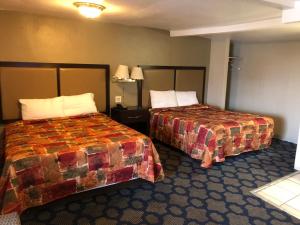 a hotel room with two beds and two lamps at Haven Inn of Chico in Chico