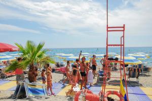 Un groupe de personnes debout sur une plage dans l'établissement Afrodite Boutique Hotel, à Bovalino Marina