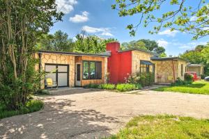 a home in the woods with a red at Remodeled Retro Home with Deck, Walk to Main Street! in Blanco