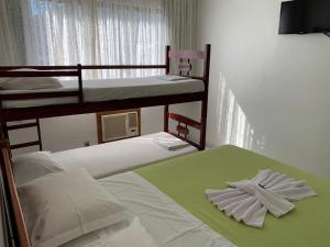 um quarto com 2 beliches e toalhas em Hotel Linhares em Itajaí