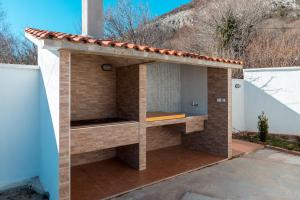 una barbacoa de ladrillo con techo en una casa en Holiday Home Marija, en Budva