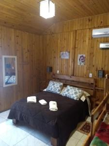 1 dormitorio con 1 cama con 2 toallas en Chales Manaca da Serra en Urubici