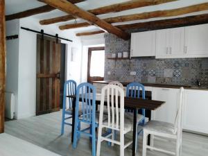 cocina con mesa de madera y sillas azules en Casa Rural Teresa, en El Molar