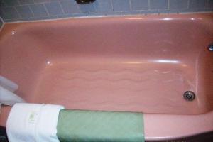 a pink bath tub with a towel laying in it at Hilander Motel in Mountain Home