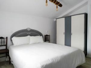 1 dormitorio con 1 cama blanca grande y 2 sillas en Casa Rural Teresa, en El Molar 19 fotos más