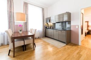 a kitchen with a wooden table and a dining room at Aparthotel Am Schloss in Dresden