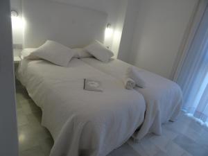 A bed or beds in a room at Domus Apartamentos Granada con parking gratuito en pleno centro