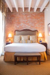 a bedroom with a large bed with a brick wall at French Market Inn in New Orleans