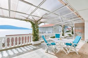 a patio with a table and chairs and a view of the water at Bayview Apartments in Tivat