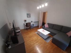 a living room with a couch and a table at Apartman Kod Kestena in Osijek